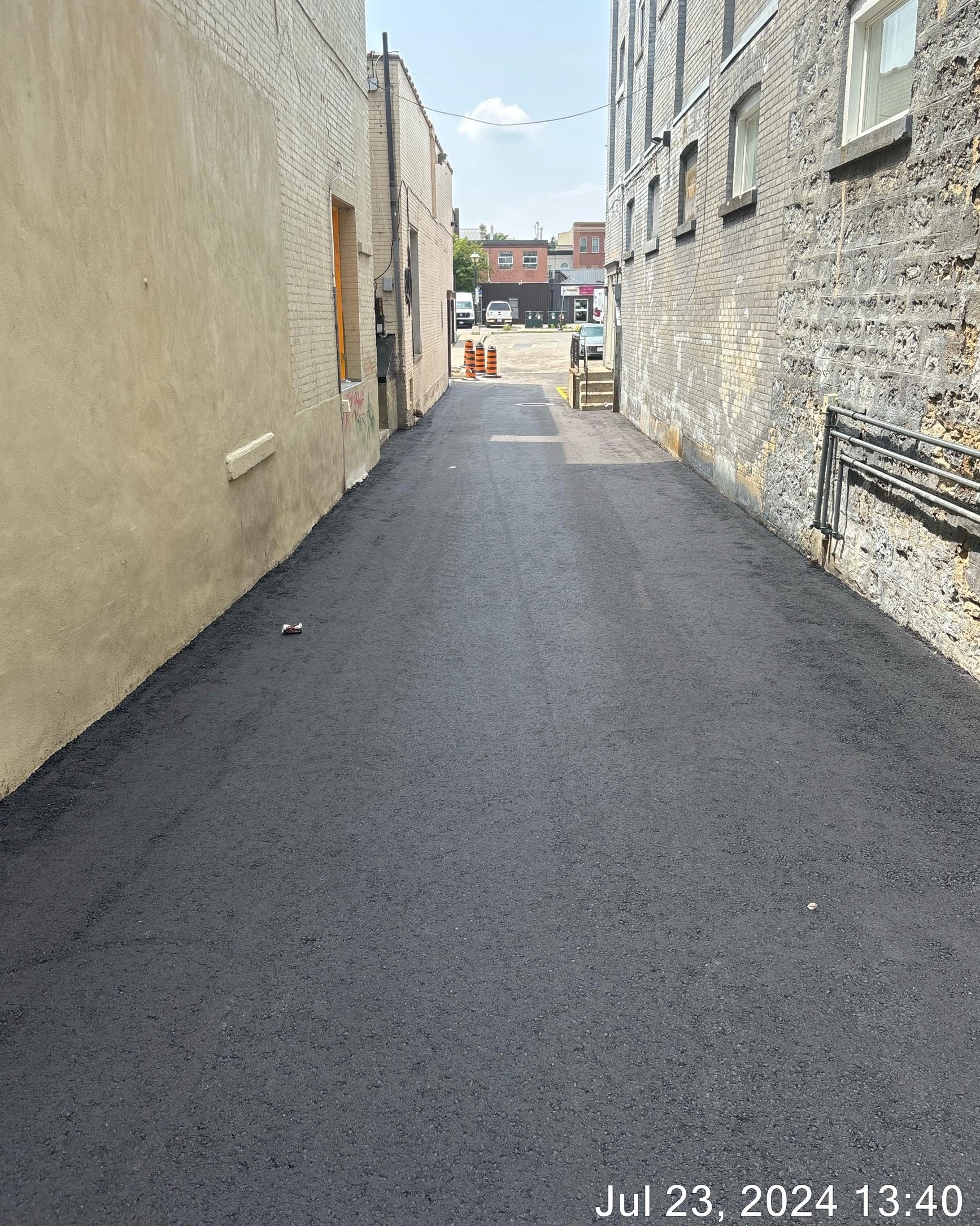 Dickson St Lot Storm Improvement (Construction) - Newly paved alleyway with buildings on both sides