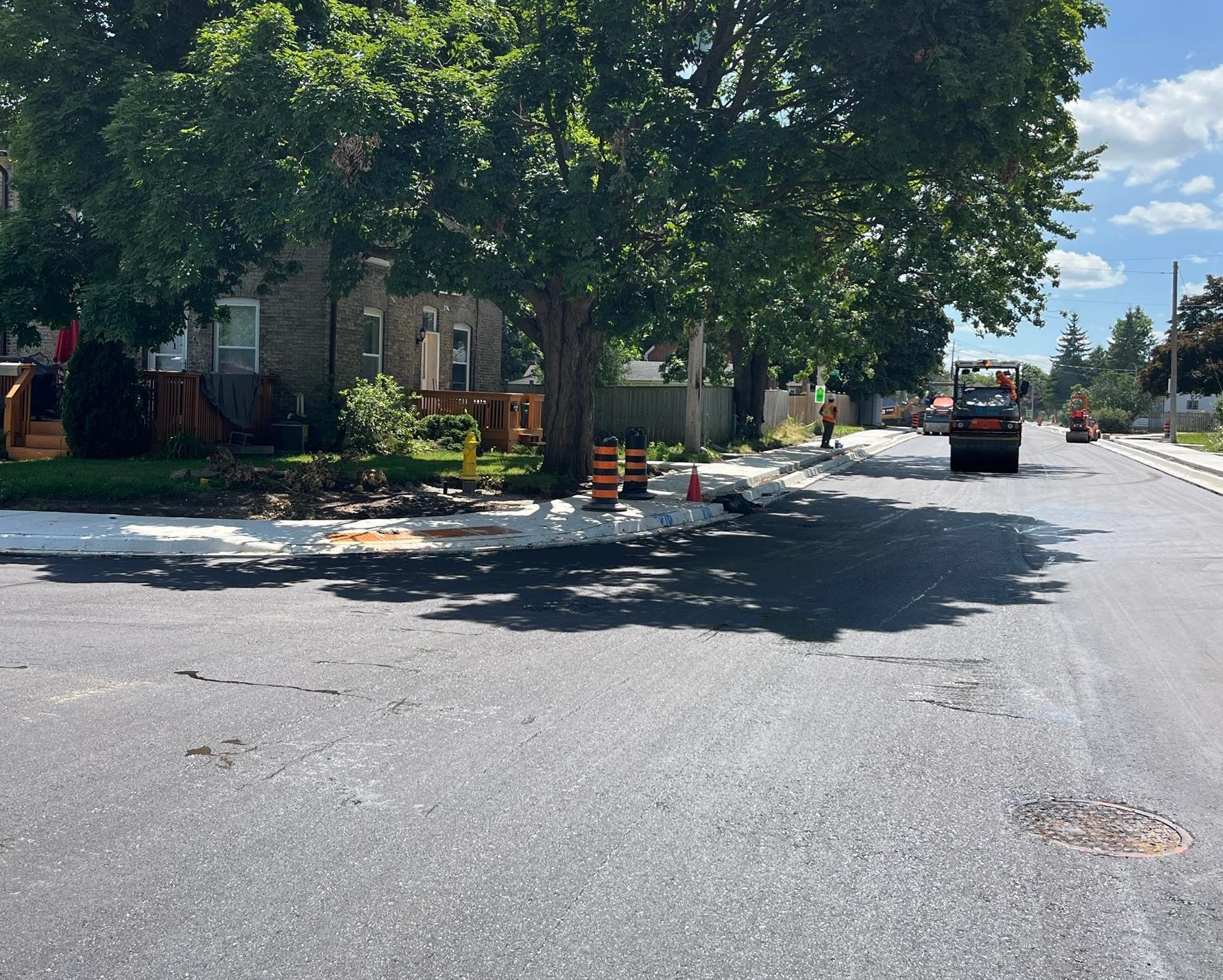 Oxford St (Construction) - Newly paved road with concrete sidewalks, curbs, and construction equipment