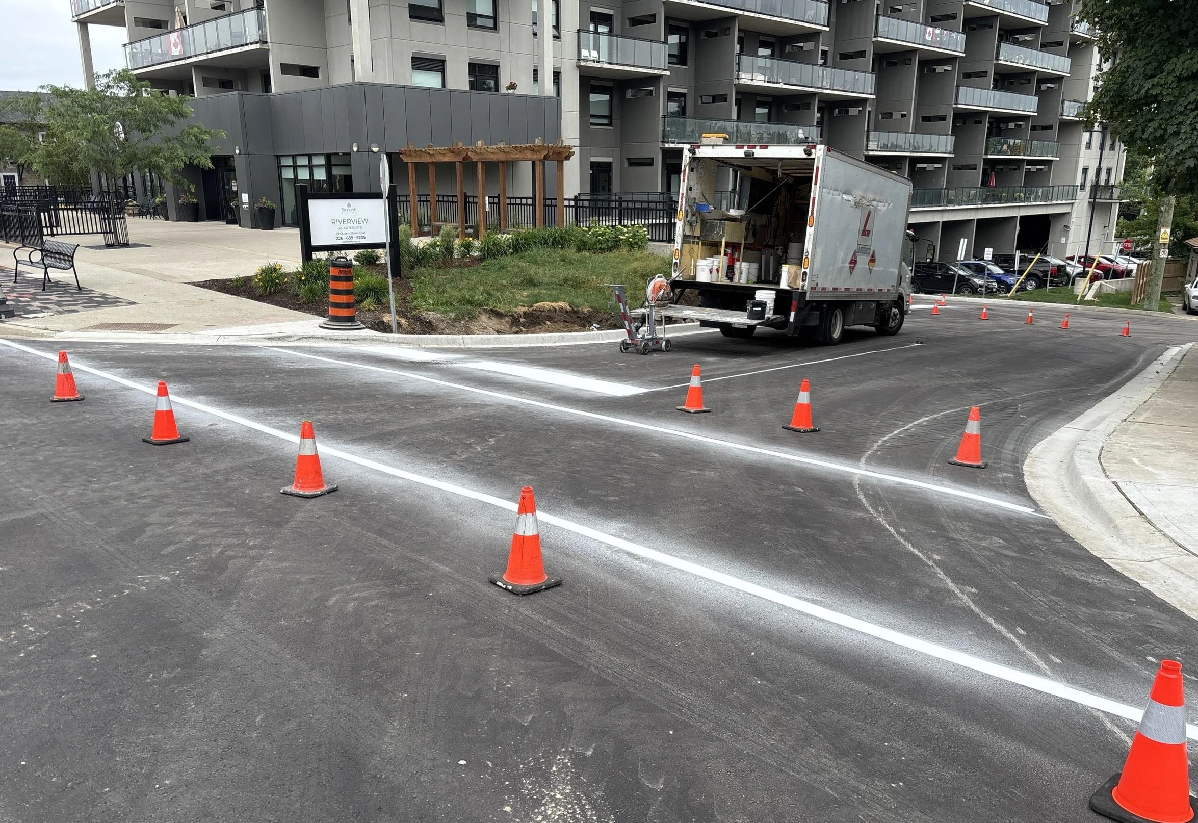 Cooper St (Construction) - Newly paved road with fresh line markings and apartment building